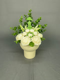 Buddha Peace candle bouquet with green Buddha centerpiece, white flowers, lush green foliage in a white ribbed ceramic pot