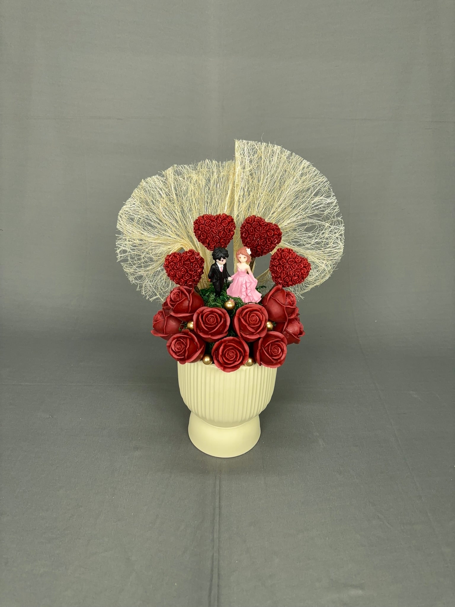 Stage Romance red rose candle bouquet with couple figurine and heart-shaped rose accents in pedestal vase