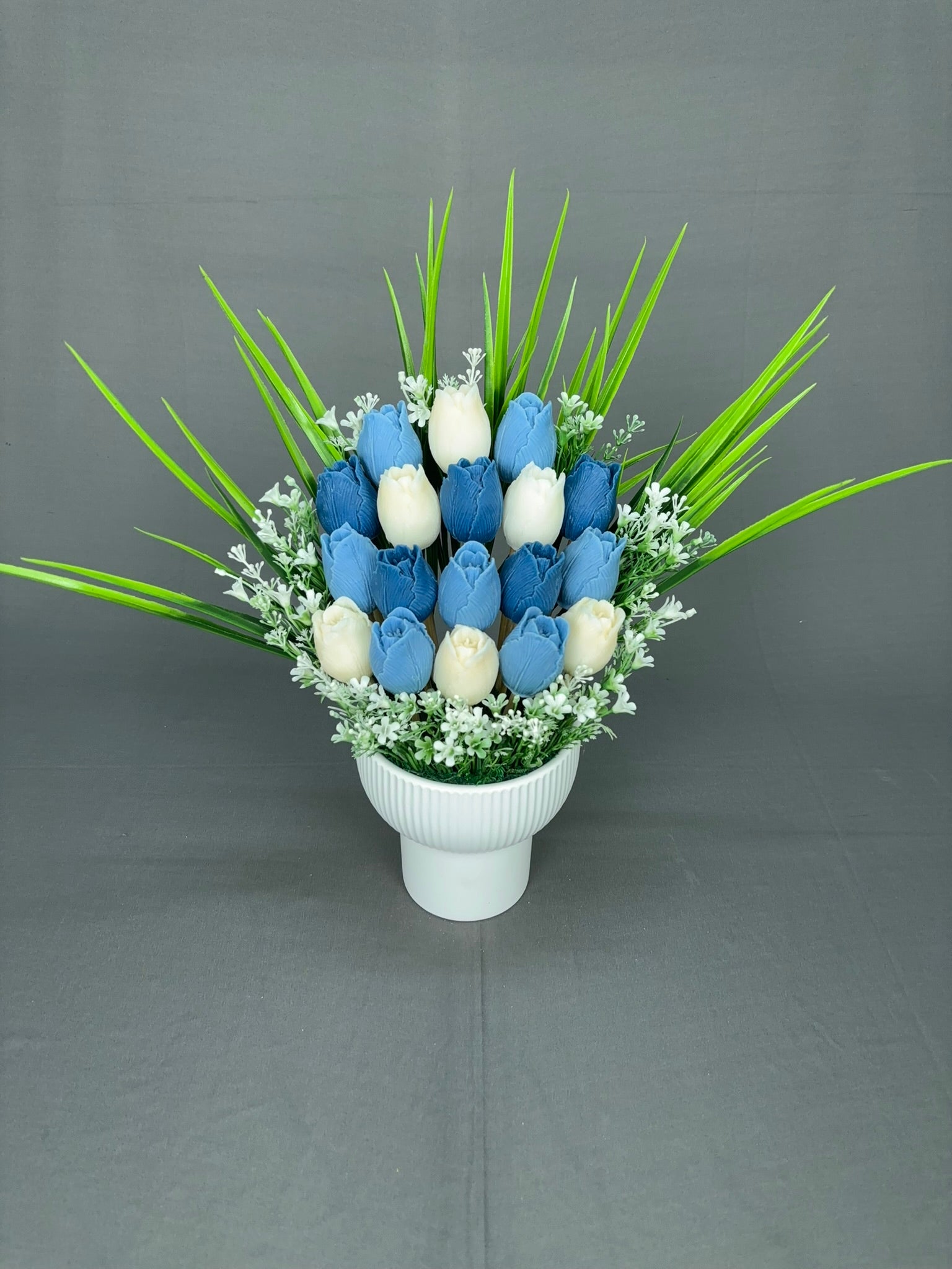 Tulip Garden Blue tulip candle bouquet with blue and white tulips, green leaves and white fillers in a white ribbed ceramic pot