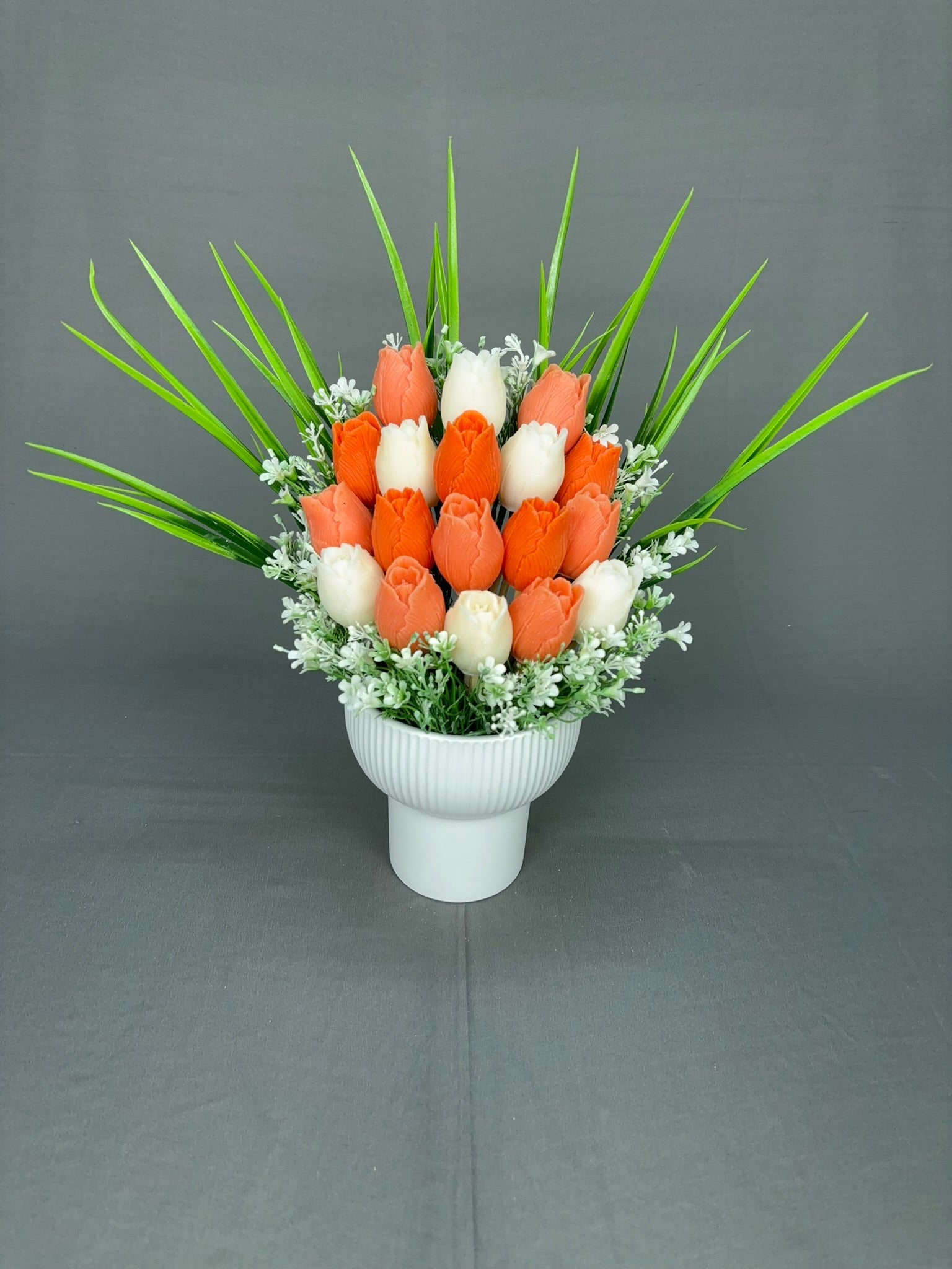 Tulip Garden Peach tulip candle bouquet with peach orange and white tulips, green leaves and white fillers in a white ribbed ceramic pot